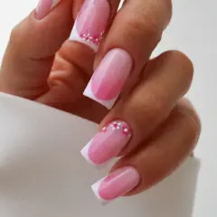 Delikatny french manicure z różowym ombre i ozdobnymi kwiatuszkami. Idealny pomysł, czym zrobić french, by wyglądał subtelnie i kobieco.