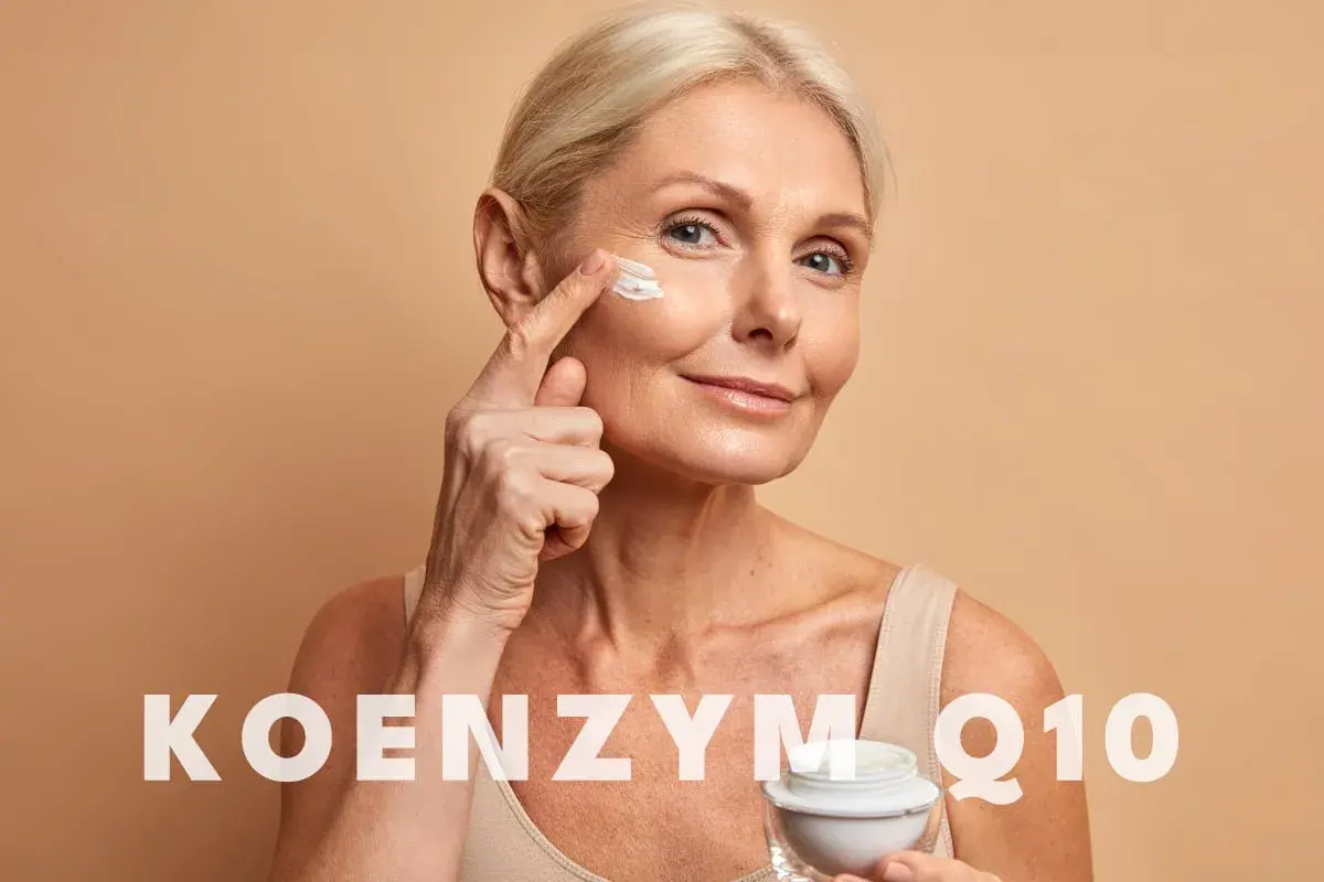 Kobieta aplikuje krem pod oczy. Czy wiesz, co to jest koenzym Q10? To składnik, który może pomóc w pielęgnacji skóry.