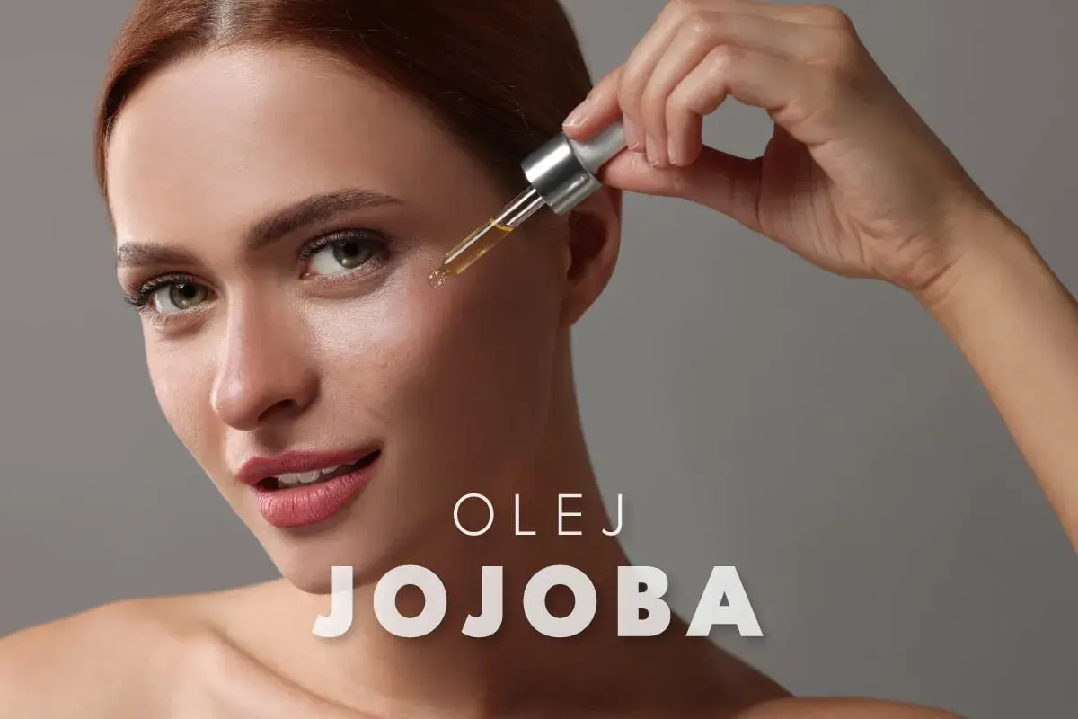 Kobieta aplikuje kroplę olejku jojoba na twarz, by nadać jej blask.