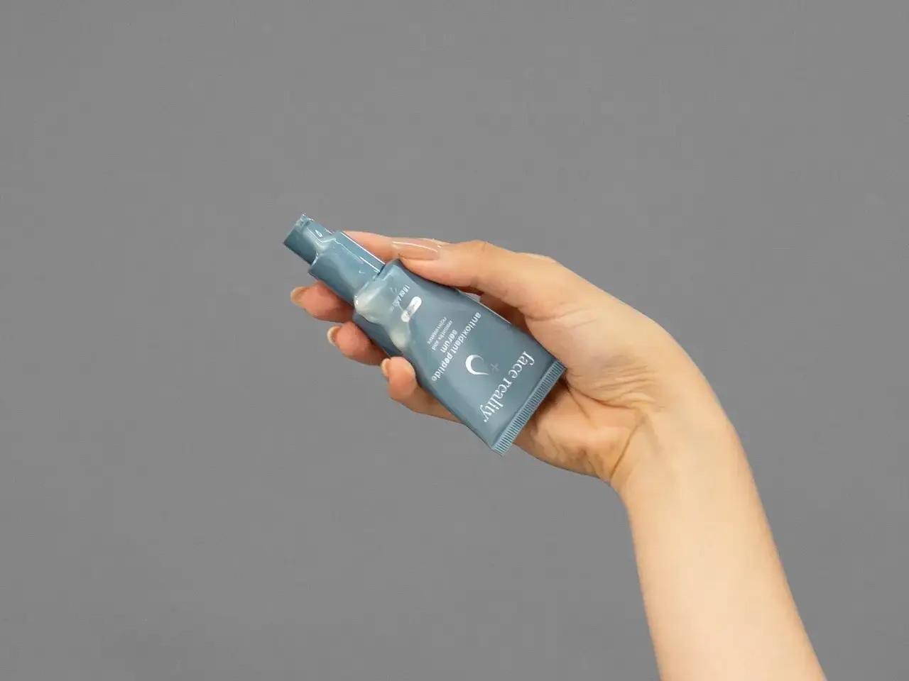 Dłoń trzyma tubkę serum z napisem